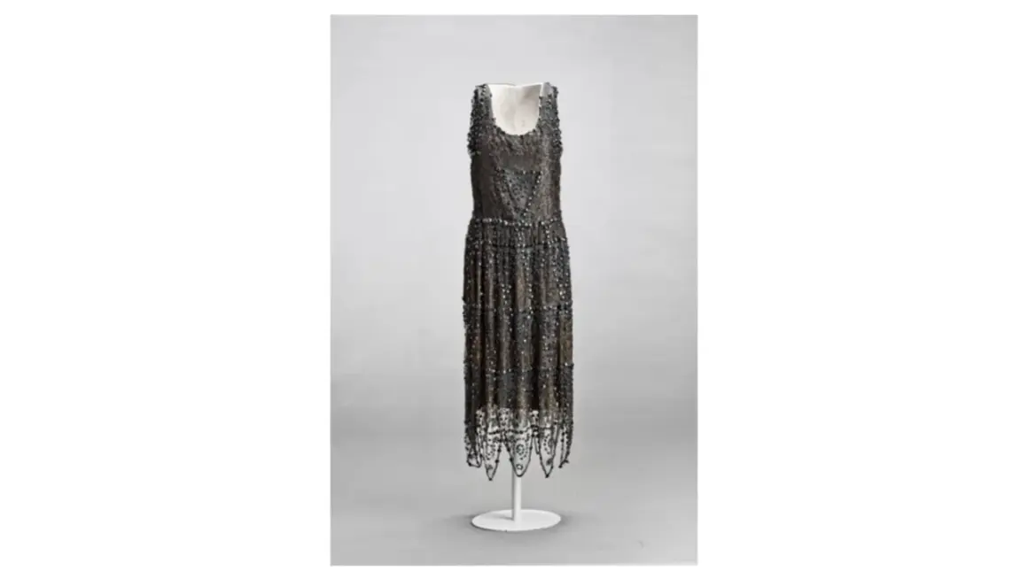 Vestido de noche de Madeleine Vionnet, con intrincados bordados y flecos, un ejemplo de su maestría en el corte al bies.
