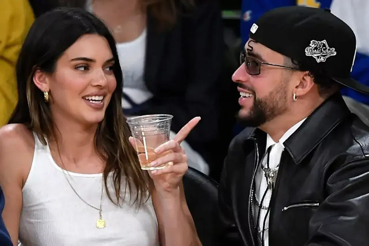 Kendall Jenner y Bad Bunny riendo y compartiendo un momento en un evento deportivo.