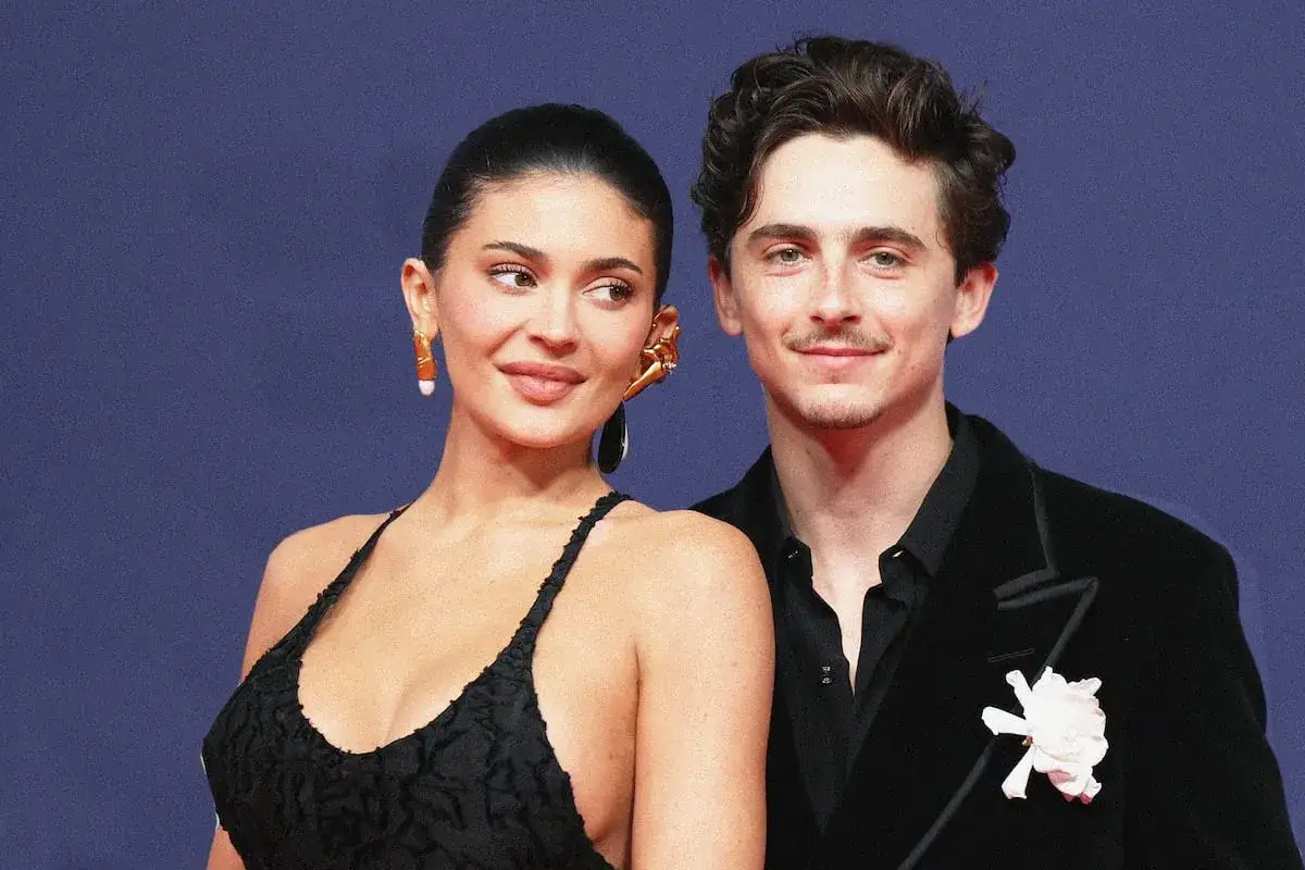 Kylie Jenner y Timoth&eacute;e Chalamet posan juntos, ella con un vestido negro y &eacute;l con un traje oscuro y una flor.