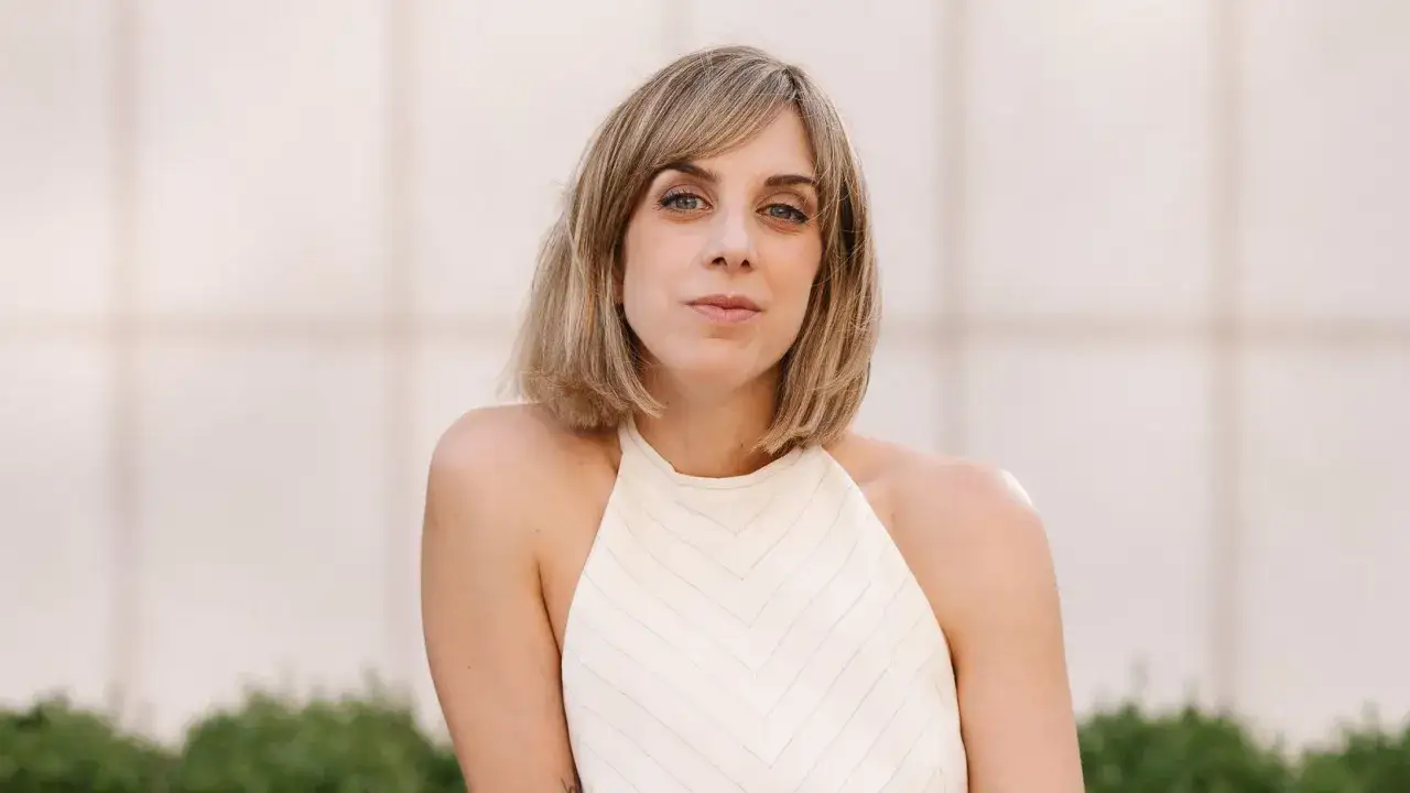 Analia Plaza, una mujer con cabello rubio corto y ojos azules, mira a la cámara con una expresión serena.
