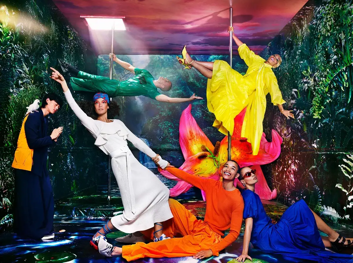 Un mundo de fantasía al estilo Tim Walker: modelos en poses acrobáticas, rodeados de vegetación exuberante y flores gigantes.