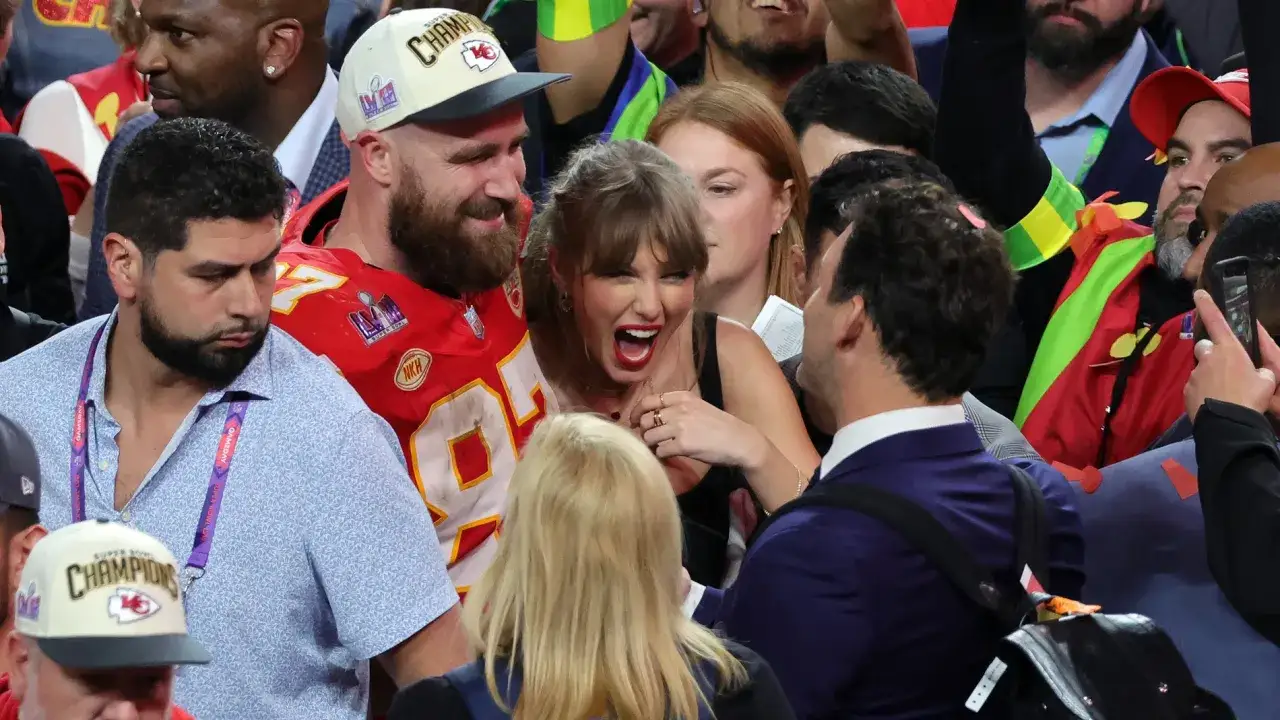 Travis Kelce y Taylor Swift celebran la victoria, rodeados de fans.