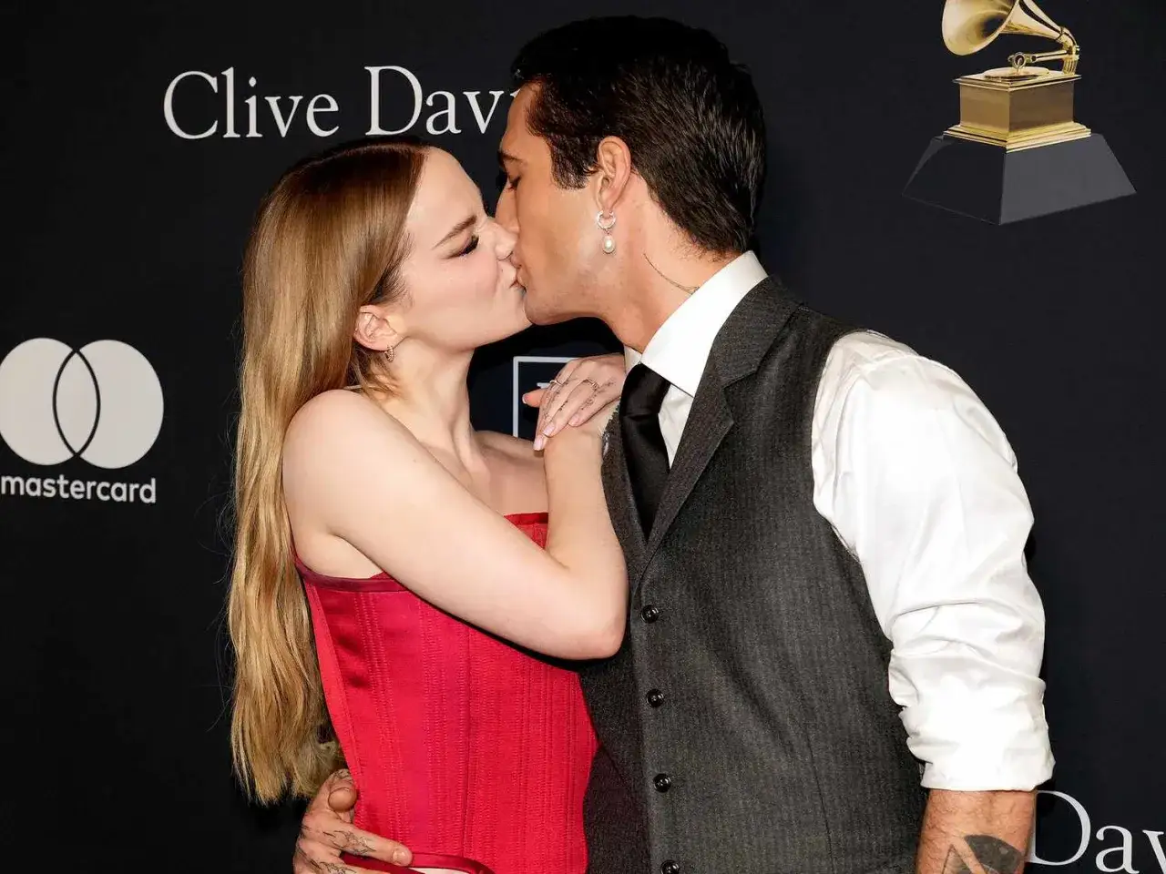 Damiano David y su pareja se besan apasionadamente en la alfombra roja.