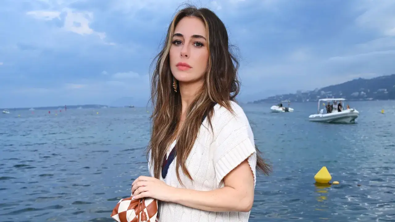 Blanca Suárez, con su melena castaña y mechas rubias, posa con un jersey blanco de punto sobre el mar azul.