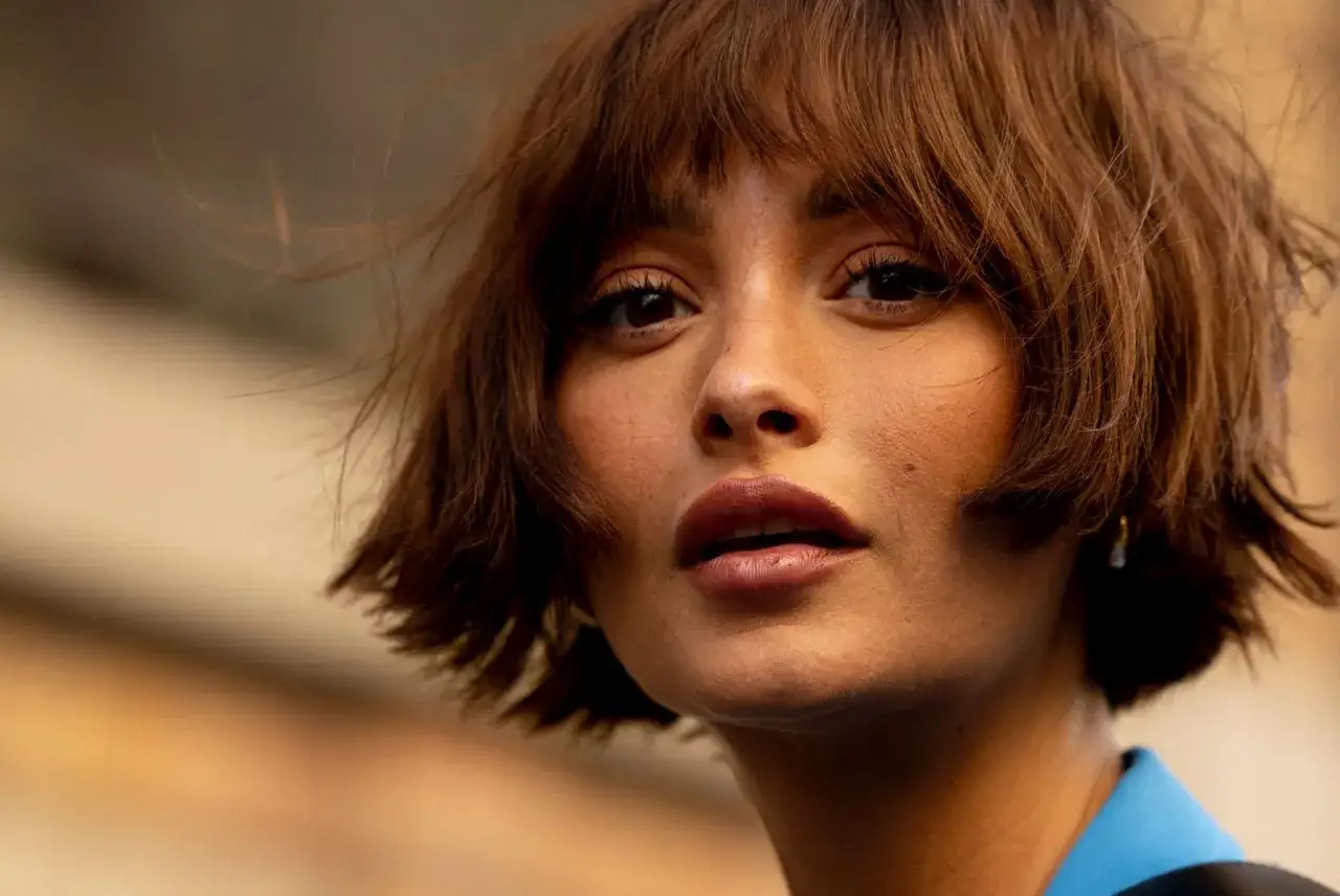 Mujer con un moderno corte de pelo corto, estilo bob desordenado, que realza sus rasgos.