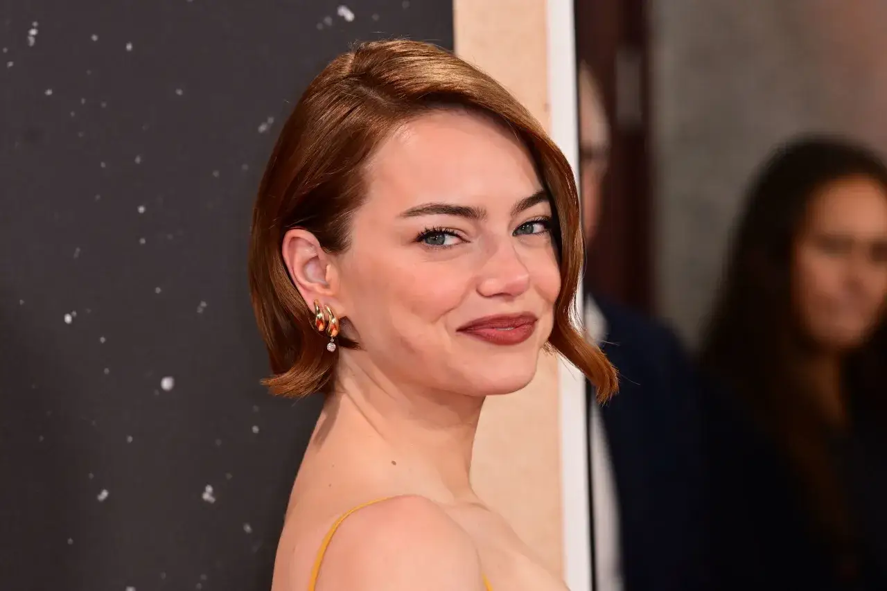 Emma Stone luce unos elegantes peinados pelo corto cobrizo, con un estilo moderno y sofisticado.