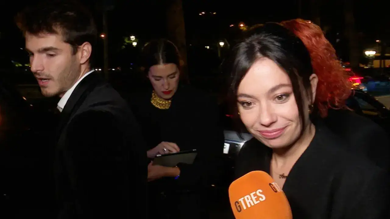 Anna Castillo sonríe a la cámara mientras su pareja y otra mujer observan un tablet.