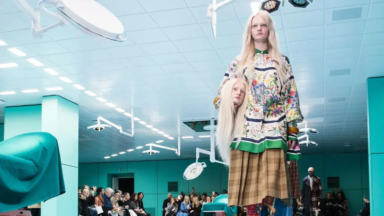 Alessandro Michele presenta un modelo con una cabeza decapitada en una pasarela surrealista.