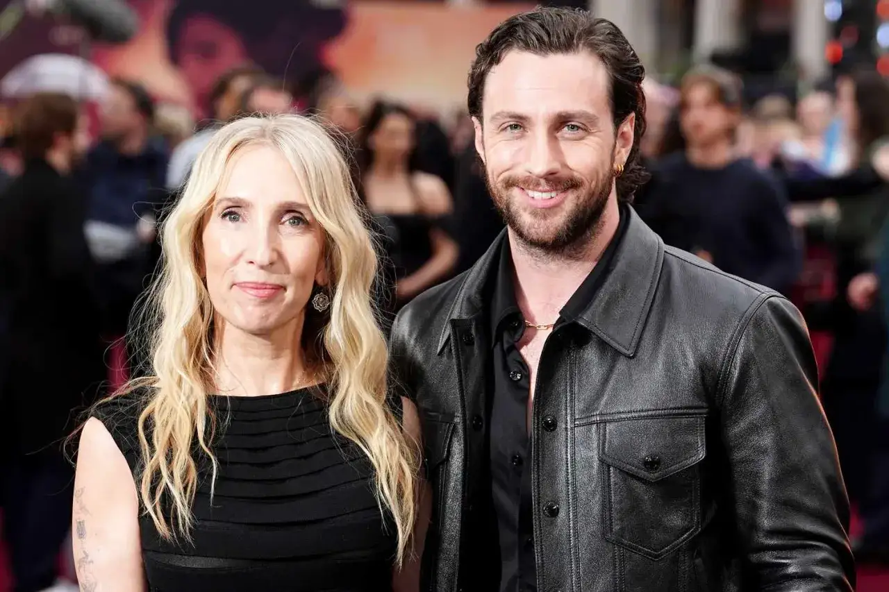 Aaron Taylor-Johnson y su pareja, Sam Taylor-Johnson, posan sonrientes en un evento.