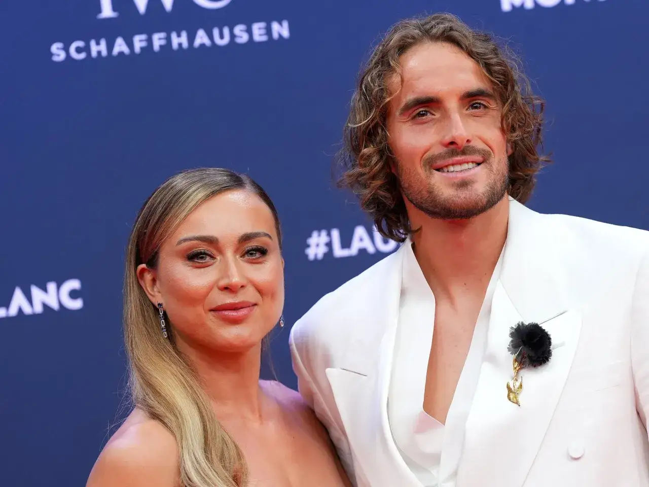 Paula Badosa y su novio, Stefanos Tsitsipas, sonríen en la alfombra roja.