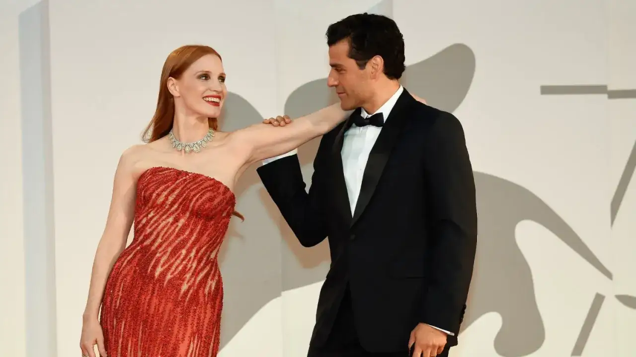 Oscar Isaac y Jessica Chastain, radiantes en la alfombra roja. Ella luce un vestido rojo brillante, él un elegante esmoquin negro.