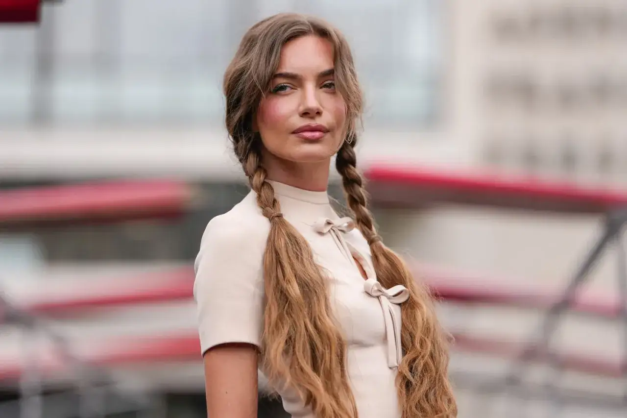 Chica con recogidos altos juveniles, luciendo un vestido beige con lazos.