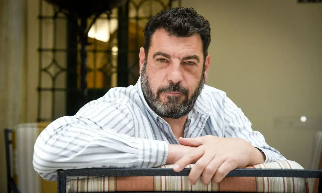 Esteban Navarro, hombre de barba canosa y mirada intensa, posa con su camisa a rayas.