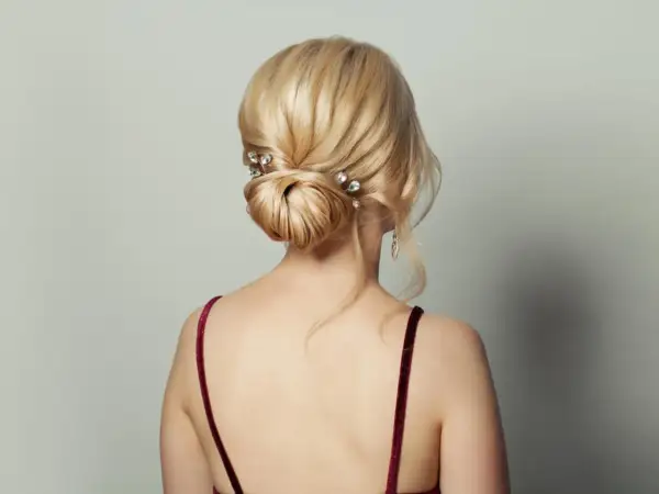 Moño bajo elegante con horquillas de cristal, ideal como peinado para invitada de boda.