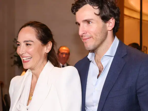Tamara Falcó e Iñigo Onieva sonríen juntos, ella con un elegante traje blanco y él con chaqueta azul.