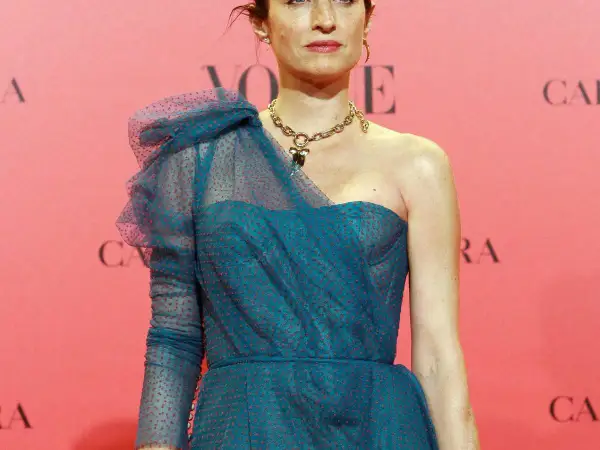 Carolina Adriana Herrera luce un elegante vestido azul con lunares rojos y un collar dorado.