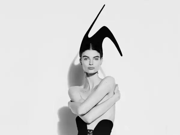 Mujer con tocado escultural negro, evocando la audacia de Elsa Schiaparelli.