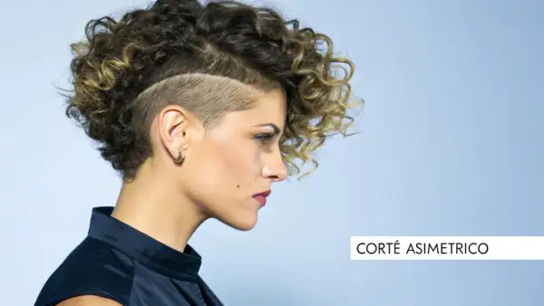 Mujer con pelo corto rizado y rapado asimétrico, luciendo un estilo audaz y moderno.