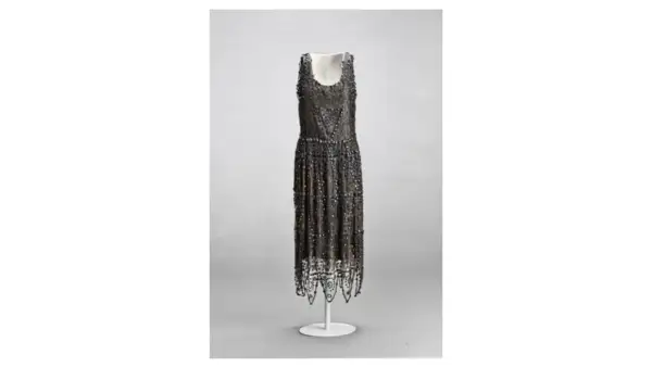 Vestido de noche de Madeleine Vionnet, con intrincados bordados y flecos, un ejemplo de su maestría en el corte al bies.