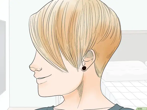 Perfil de persona con cabello rubio, mostrando la transición de pelo corto a largo. Se ve un pendiente negro.